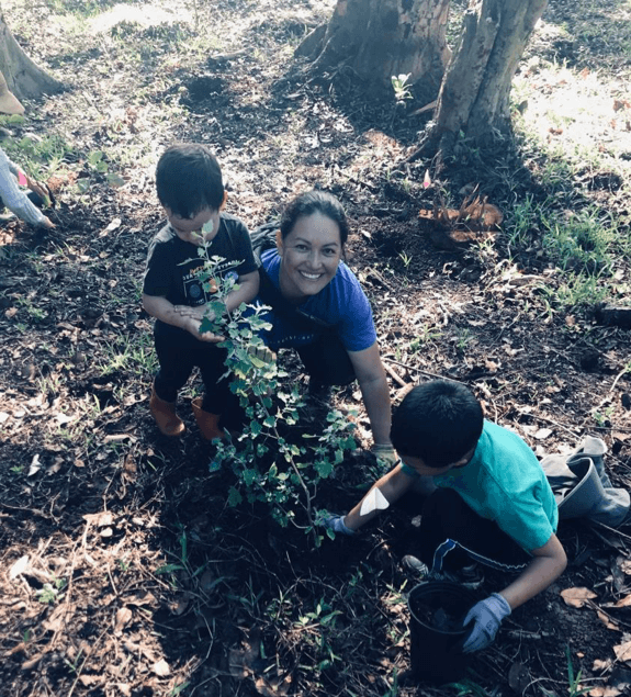 Julianna Rapu and her keiki plant an ʻāweoweo (photo by Leah Bremer).